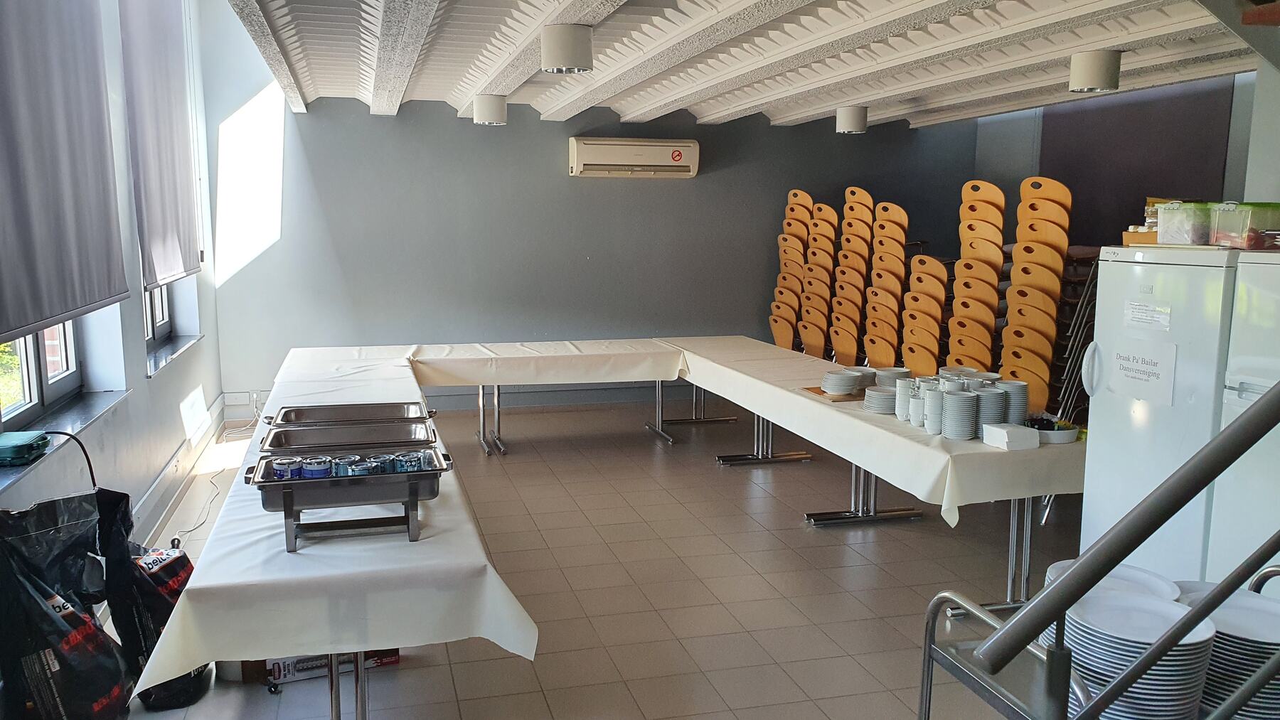 Gestapelde stoelen, borden en een buffetopstelling